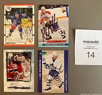 Four autographed NHL cards featuring Chris Nilan, Kirk Muller, Martin Brodeur, and Luke Richardson with a MaxSold lot number.