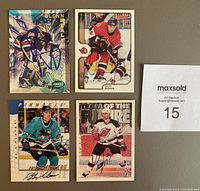 Photo showing four autographed NHL hockey cards including Glenn Healy, Radek Bonk, Patrick Marleau, and Scott Niedermayer cards