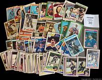 Overview photo showing a spread and stack of vintage OPC hockey cards from 1973-75 through 1984-85 with various players and teams visible, many cards showing wear and damage.