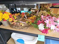 Two wreaths displayed on a shelf, one with fall colors and one with spring colors