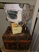 Stacked floral print box on top of vintage-style figure print box and wooden chest