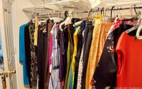 Clothing rack with various ladies' clothing items in size 12-14, including dresses, skirts, and tops.