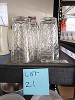 Photo showing three of the clear water glasses upside down, displaying the raised dot pattern and thick glass construction.
