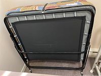 Image showing the underside metal frame with black cross braces and caster wheels for mobility