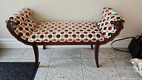 Full view of the hall bench showing the curved wood frame and patterned upholstered seat and backrest.