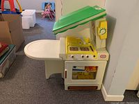 Side view of the Little Tikes kid's play kitchen showing stove, oven, phone, and table extension.
