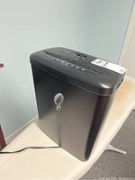 Full view of black Omnitech paper shredder showing body and power cord.
