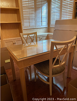 Solid oak desk with glass top in a room with wooden floors and built-in shelves. Two matching chairs at the desk.
