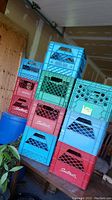 Stack of 10 vintage milk crates in red, blue, teal, and green colors stacked vertically and horizontally