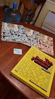 Three vintage comic reprint booklets on table showing two Cavalcade volumes and one Sunday Funnies booklet.