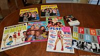 Photo shows a collection of Spice Girls magazines, fan magazines, official sticker collection, and trading cards spread on a table.