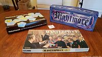 Photo showing all three vintage board game boxes: National Geographic Global Pursuit, Masterpiece The Art Auction Game, Nightmare The Video Board Game.