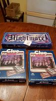 Image showing all three game boxes, two Clue VCR games and one Nightmare game stacked on table.