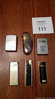 Overview of six lighters on wooden surface showing various designs and shapes