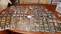 Wide view of approximately 140 Hercules trading cards spread across table surface showing card fronts and backs.
