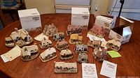 Overview of all 17 Liliput Lane miniature houses on table with original boxes and certificates.