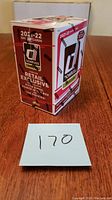 Front and side views of the factory sealed 2021-22 Donruss Soccer Cards box on a wooden surface with lot number 170 in front.
