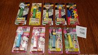 All 10 Pez dispensers in original packaging from multiple series arranged on surface