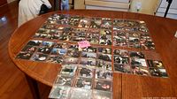 Overview of 89 Sleepy Hollow trading cards spread out on a wooden table, showing front images of cards with scenes from the TV series.