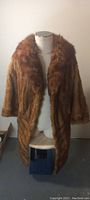 Front view of vintage mink fur jacket on mannequin, showing large collar and natural brown fur texture.