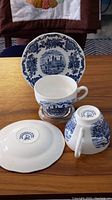 Set of vintage Wedgwood cup and saucer with detailed blue scenic print on white porcelain.
