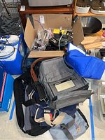 Overview of cardboard box of audio gear and stacked equipment bags