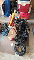 Overview of broadcast lighting equipment including Arri 309 light, mounting hardware, gel rolls, and various cables and accessories in bags.