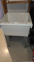 Full front view of the white utility sink showing size and structure.