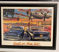 Framed color poster titled 'Lost in the 50's' showing vintage cars and airplane over a terminal during sunset.