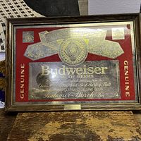 Full photo of the framed Budweiser sign and plaque with gold foil on red background