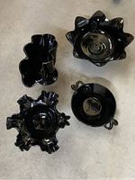 Top view showing the four black glass pieces including the vase and decorative bowls on a flat surface.