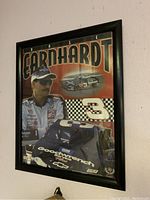 Framed Dale Earnhardt race car driver poster hanging on wall showing driver, race car, and number 3.