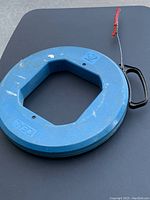 Blue circular Ideal fish tape with black handle and red tape on steel fish tape end, showing used condition and overall good shape