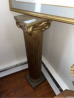 Front and angled view showing the full gold plaster column with decorated capital and square base placement near wall and floor vent.
