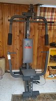 Front view of Weider 8510 home gym machine including padded seat, backrest, and various exercise handles and bars.