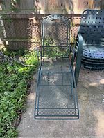 Top view of metal patio chaise lounge showing mesh seating and decorative backrest