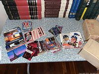 Wide shot of all trading card piles, showing multiple themed sets including baseball, basketball, movie and TV show cards.