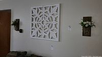 Wall art and sconces mounted on wall, showing relative size and placement