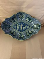 Full view of scalloped dish showing overall shape, rim detail, and interior panels