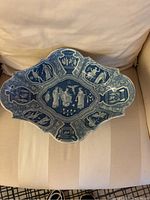 Top view of entire scalloped oblong compote dish showing central medallion and surrounding classical figures in blue and white transferware