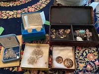Overall assortment of boxes showing cufflinks, brooches, earrings, ring and wire spool