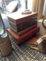 Front-side angle view showing table top lid and faux book stack design under a lamp