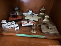 Shelf view showing porcelain inkwells front left, metal inkwells back left, blotters back right