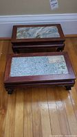 Front view showing two rosewood stands with different marble patterns stacked on the floor.