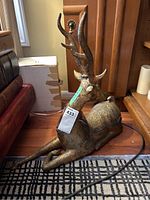 Full view of the reclining reindeer sculpture showing antlers and body.