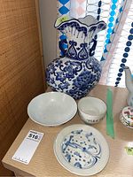 Overview of all four pieces: vase, two bowls, plate