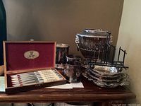 Wide view of all items on table: knife set, tumblers, ice bucket, rack, trays