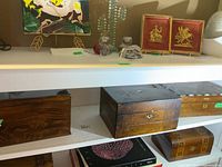 Three wooden boxes displayed side by side on shelf