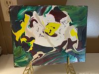 Front view of the abstract painting showing swirling green, yellow, white, and brown shapes on canvas