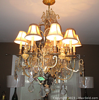 Overall view of chandelier lit showing eight fabric shades and crystal prisms